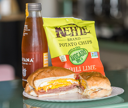 A Taylor Ham, Egg, and Cheese accompanied by a bag of chips and tea.