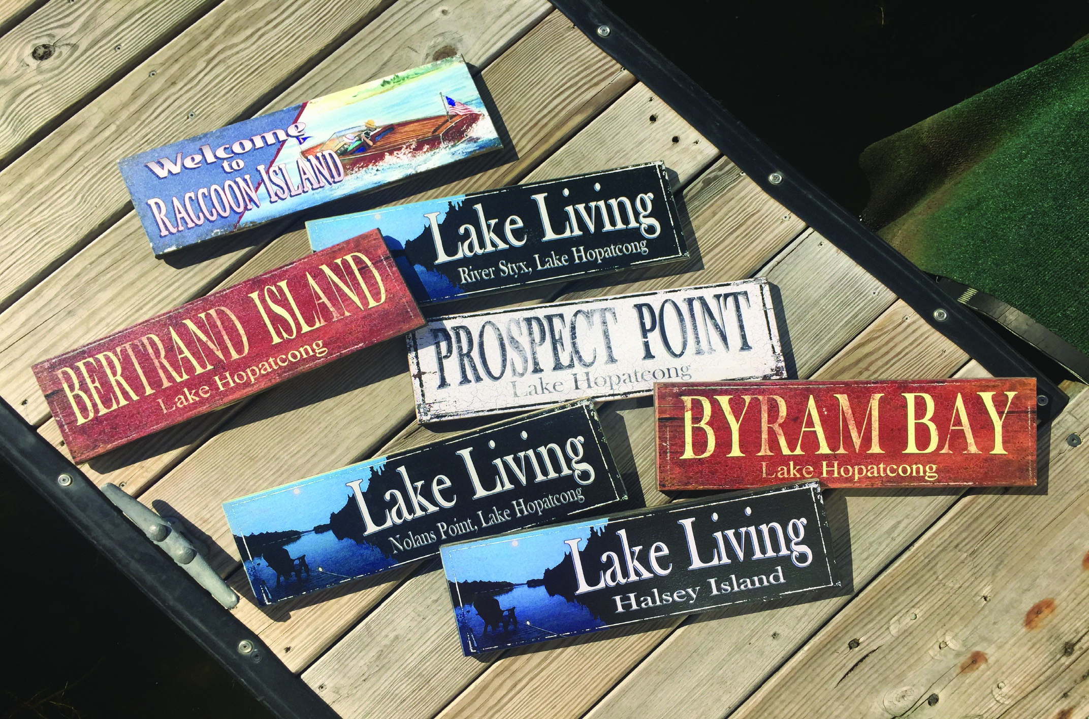 A variety of lake signs laid out on a dock.